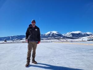 Art, winner of free shades Fridays in front of a snowy capped mountain